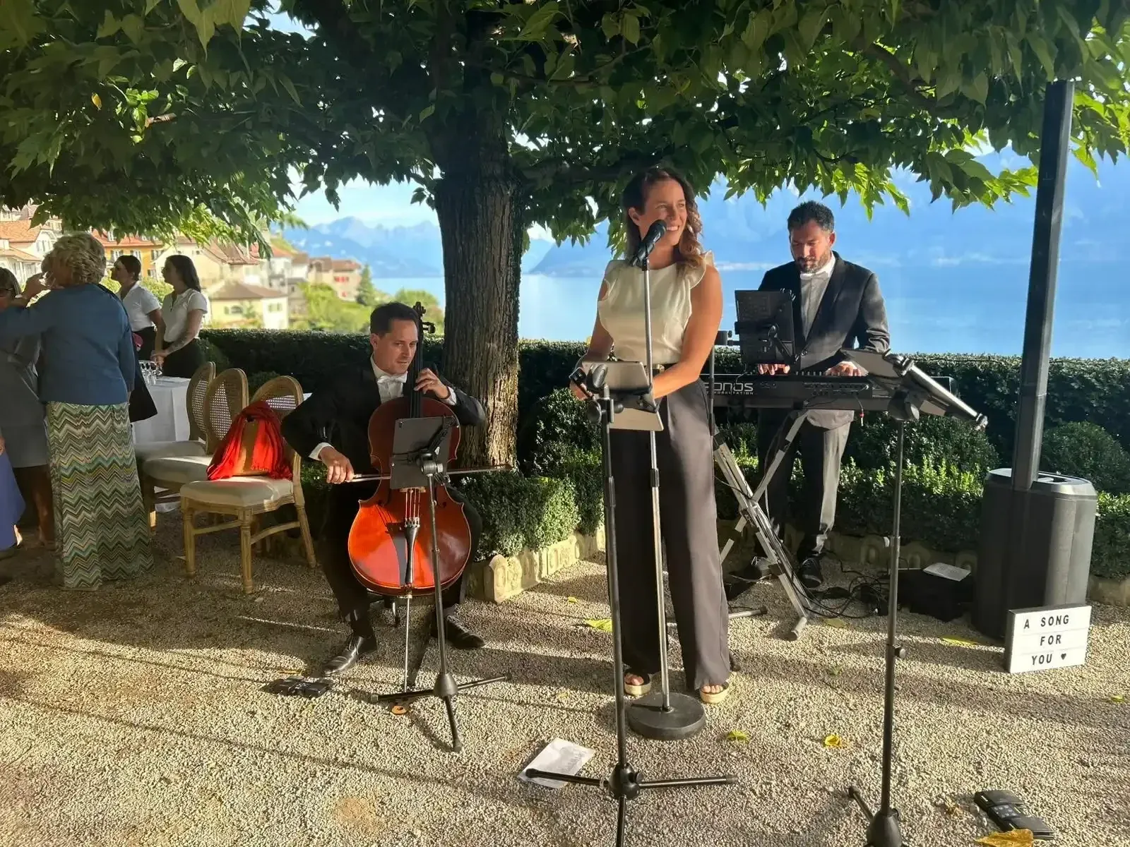 Natacha Milan, Ivan Tupinier et Benjamin Dupré jouent sous les arbres face au lac lors d’une réception