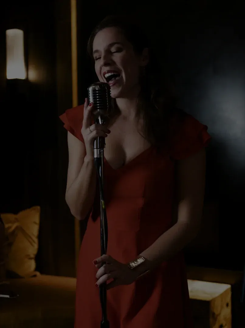 Natacha Milan, chanteuse d’A Song For You, en robe rouge au micro